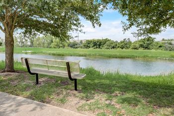 a park bench sitting next to a river at Las Brisas Apartment Homes, Round Rock, 78665